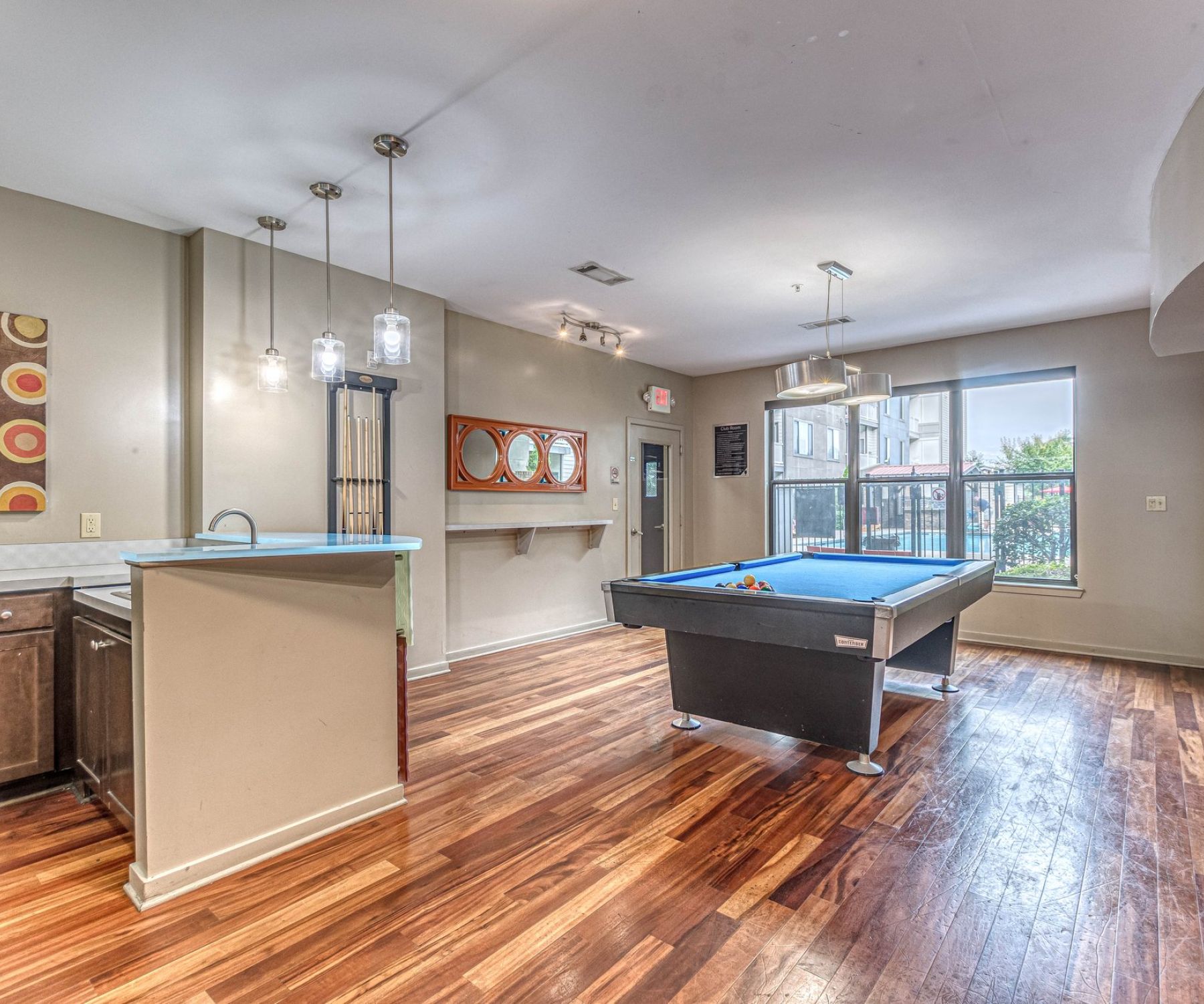 Apex West Midtown  modern game room with a pool table, hardwood floors, and large windows letting in natural light.