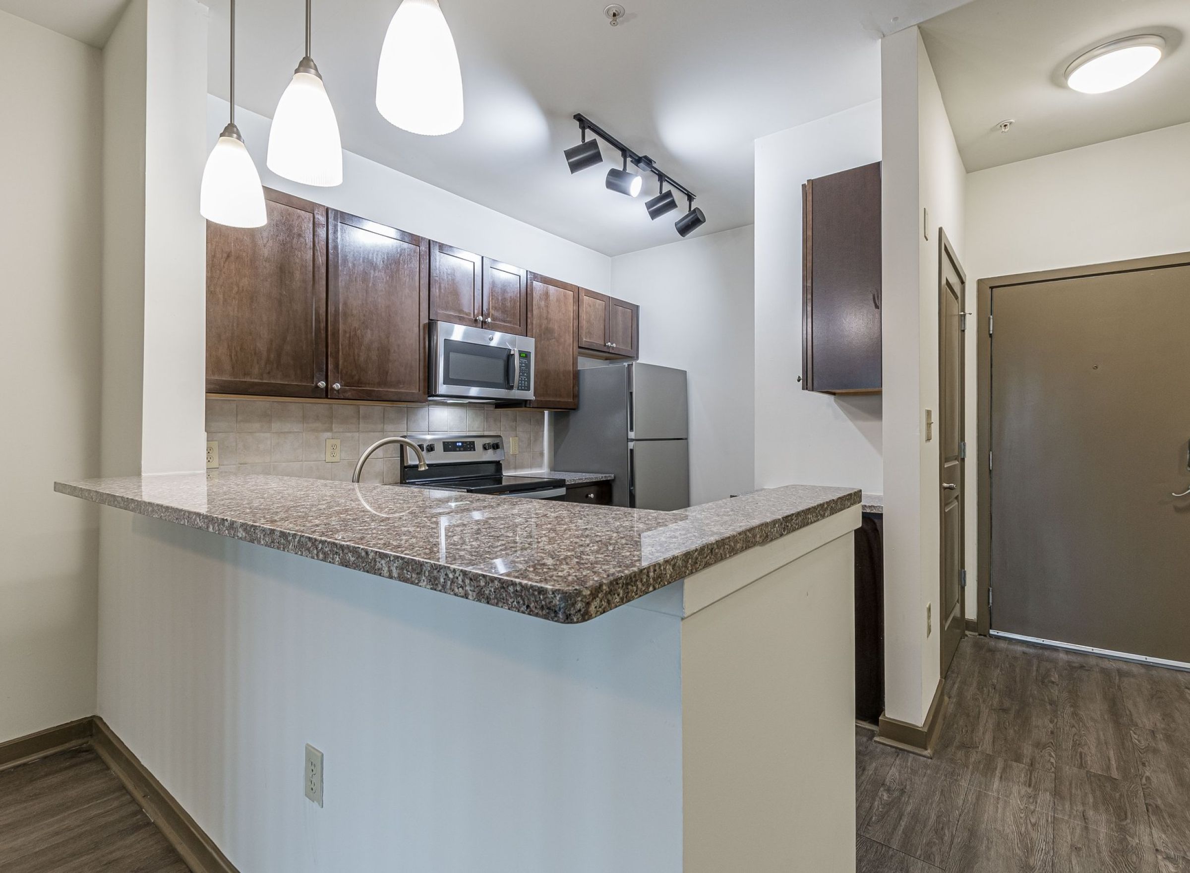 Luxury apartment kitchen with stainless steel appliances, granite countertops, and lots of storage space