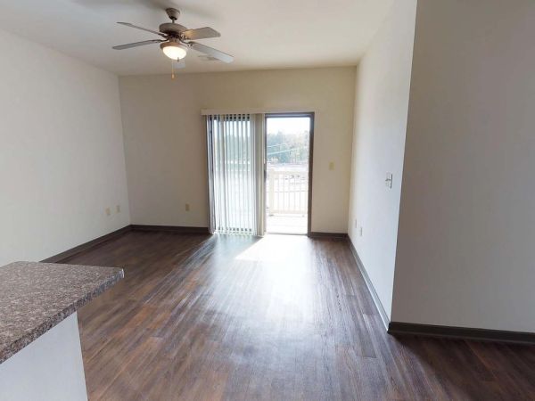 A corner package room with rows of black metal mailboxes lining two white walls under bright ceiling lights at Apex West Midtown.